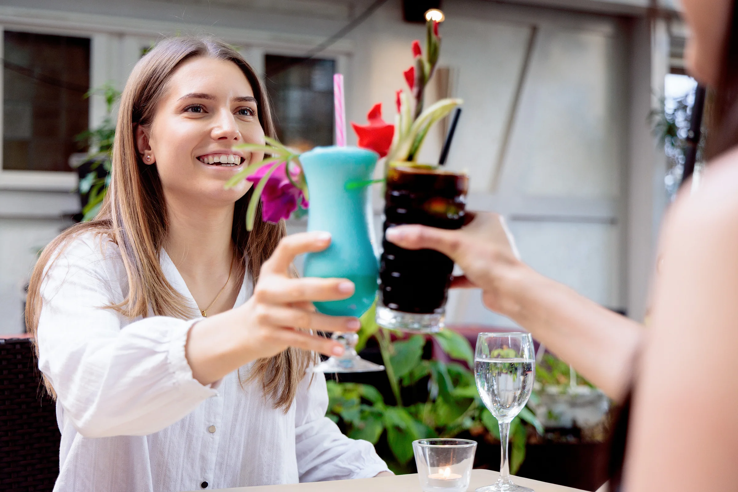 Gäste stoßen mit bunten Cocktails an